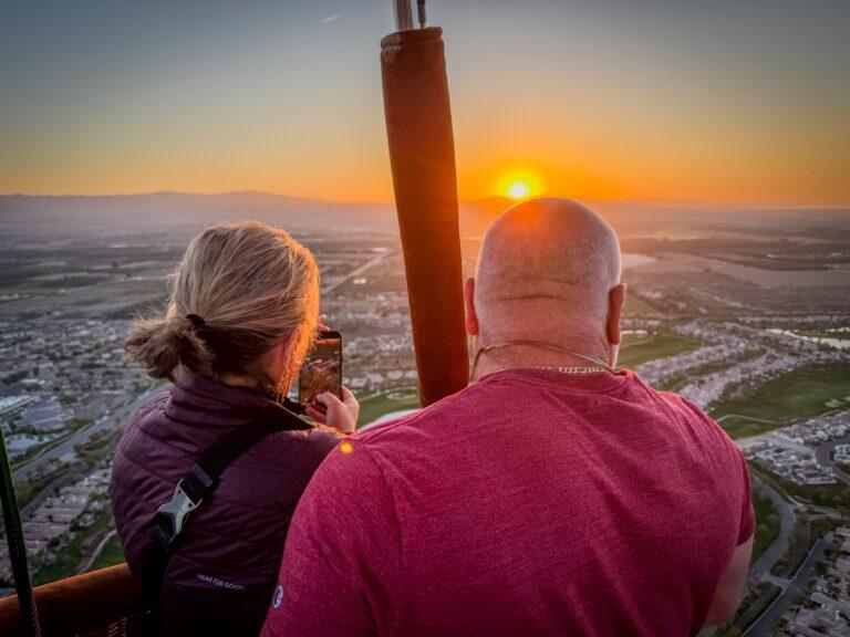 Couple watching the sunrise from a hot air balloon over Coachella Valley